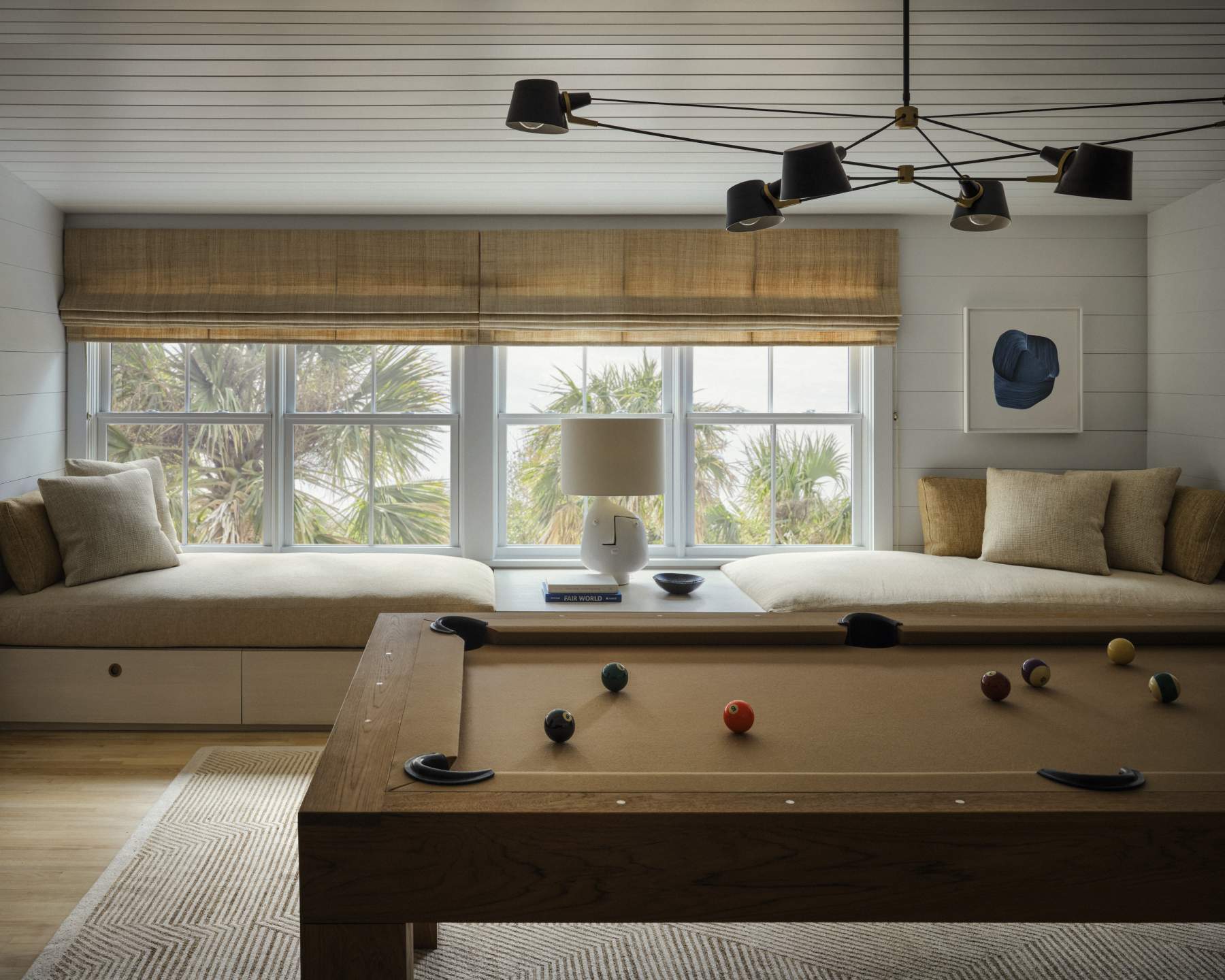 Games room with a wooden pool table, window seats and a patterned rug